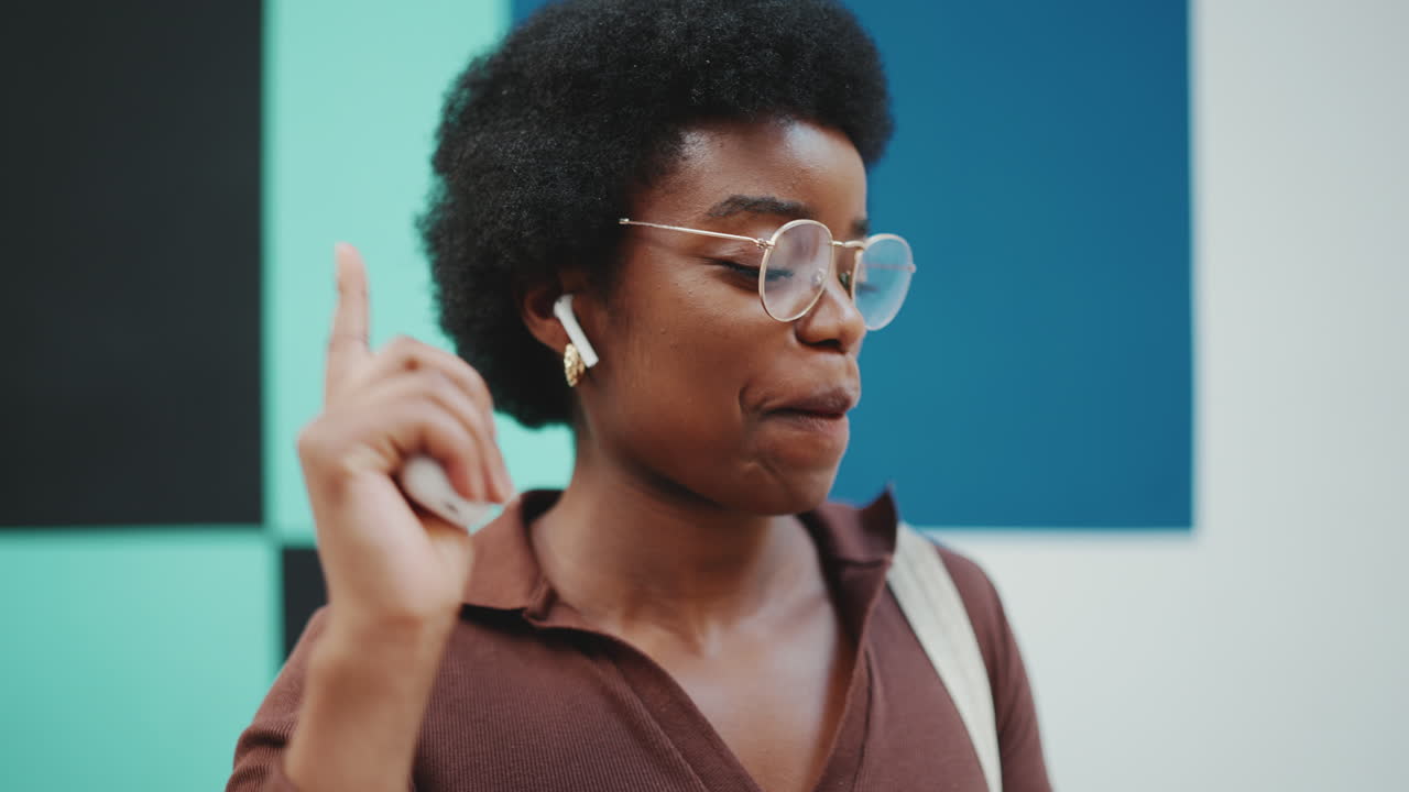Young woman listening to music with earpods and dancing