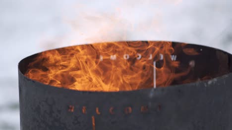 Stainless-steel-fire-barrel-burning-flames-closeup-in-winter