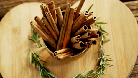 cinnamon sticks and rosemary arranged on wooden board 4k