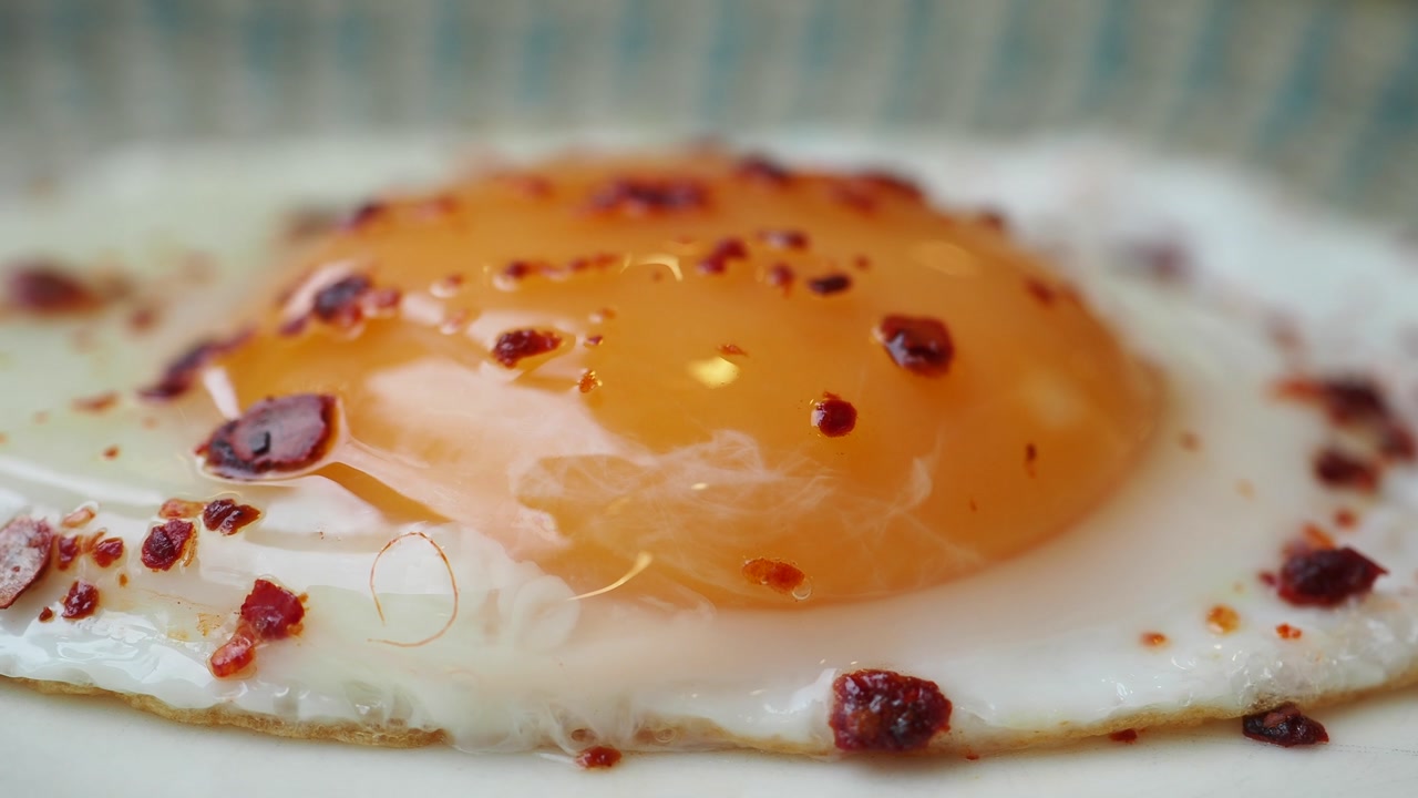 Close-up of a Fried Egg with Runny Yolk and Chili Flakes