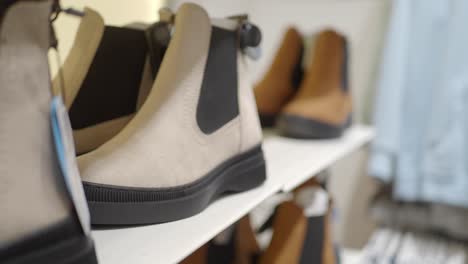 close up of beige chelsea boots on a store shelf