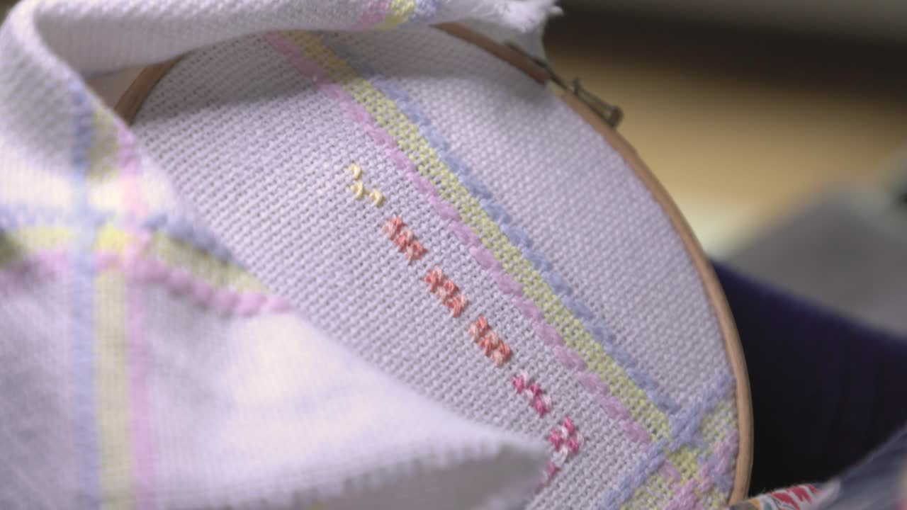 빛 아래에서 아기 담요 패턴을 매는 여자의 클로즈업