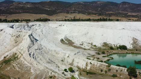 aerial view of white mineral rich mountain terraces filled with thermal pools in the world famous pamukkale turkey on a sunny summer day