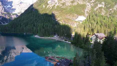 Toma-Aérea-Sobre-El-Lago-Di-Braies-Y-Su-Muelle-De-Madera-Que-Revela-Una-Iglesia-De-La-Segunda-Guerra-Mundial