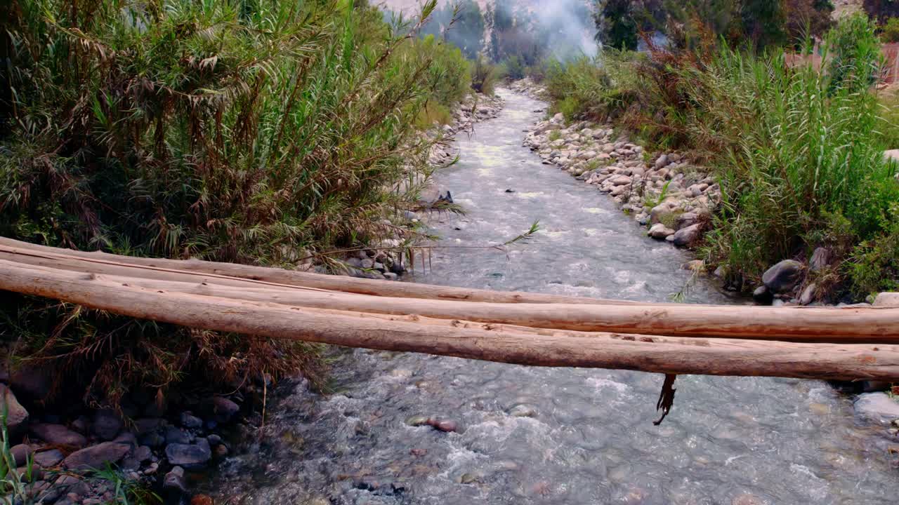 camino de agua que fluye en el río con piedras y hierba verde