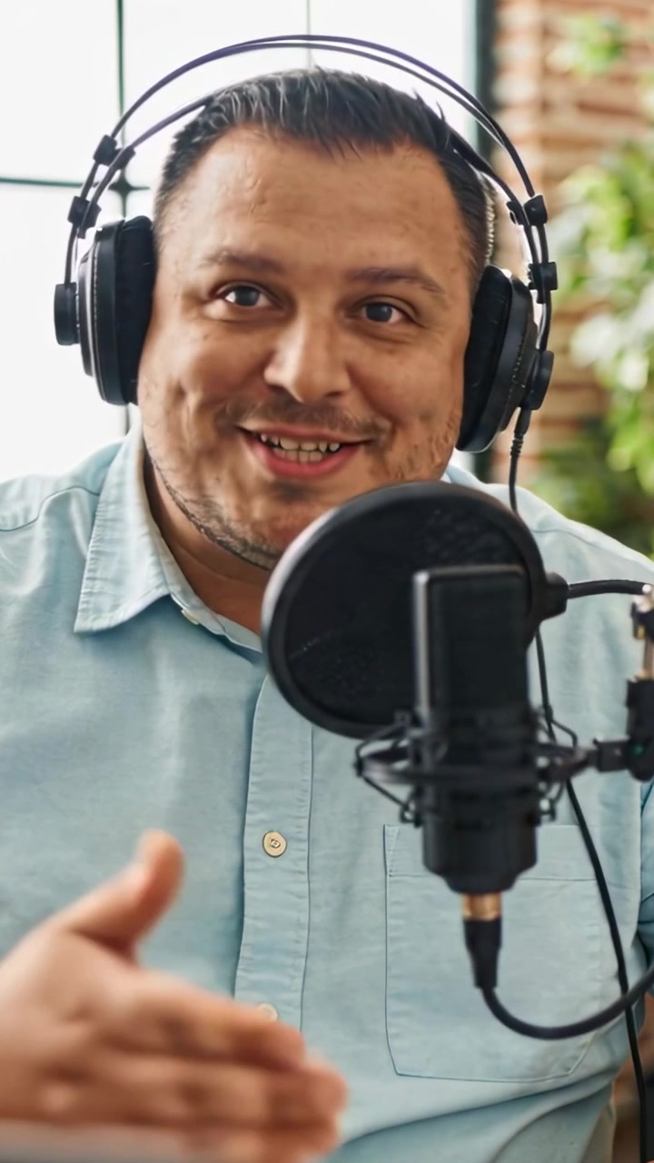 Vertikal video: Optagelse starter, podcastvært taler ind i mikrofon i studie, blå skjorte, headset