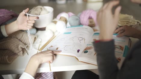 la mano del diseñador de moda señalando el boceto de la ropa en el libro