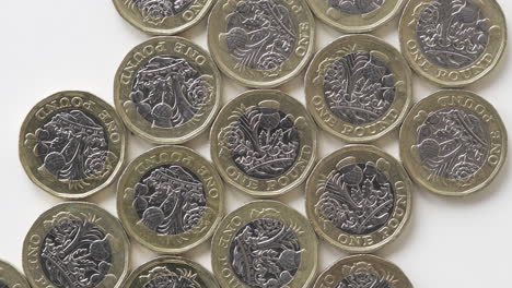 Rotating-Reverse-Of-2017-British-1-Pound-Coins-Laid-Flat-On-A-White-Surface---Top-Shot