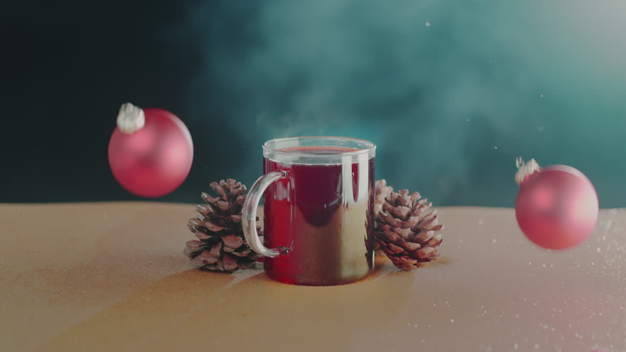 크리스마스 장식이 떨어져서 주변 조각으로 부서지는 동안 머그잔이 테이블 위에 놓여 있습니다.