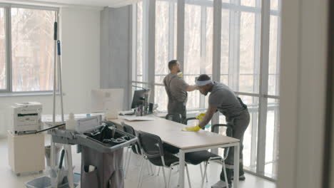 and arabic cleaning man cleaning the window panes and a desk inside an office 2