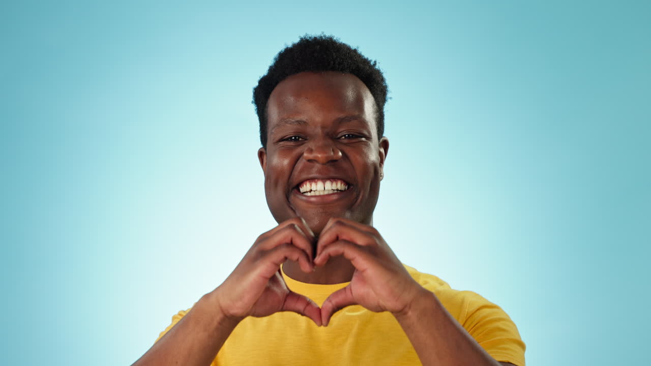 Felice, viso e un uomo di colore con le mani a forma di cuore
