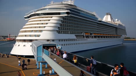 passengers boarding a large cruise ship at port