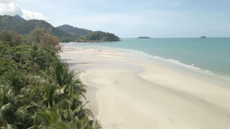 scenic aerial view on koh chang tropical island with white sand and coconut palm trees with ocean waves in amazing thailand