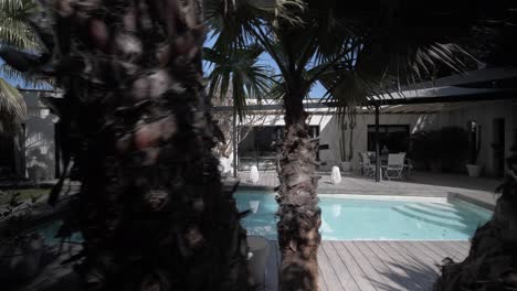 slow establishing shot of a villas garden with outdoor seating and private pool