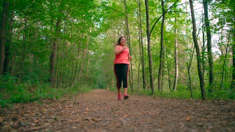 a woman trail runner running in a tropical forest shot from a low angle