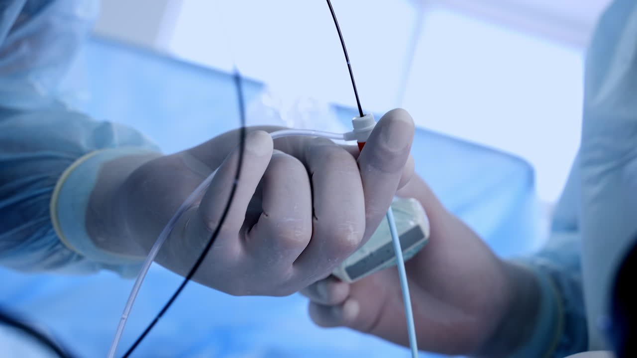 Surgeon's hands in latex gloves holding instruments during operation. Doctor uses equipment for vascular surgery. Close up.