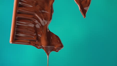 close up of melting chocolate bar against blue coloured background with copy space 4