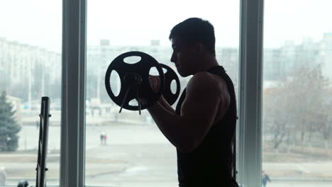 man working out with barbells in gym