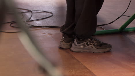 persona con zapatillas de deporte en el escenario