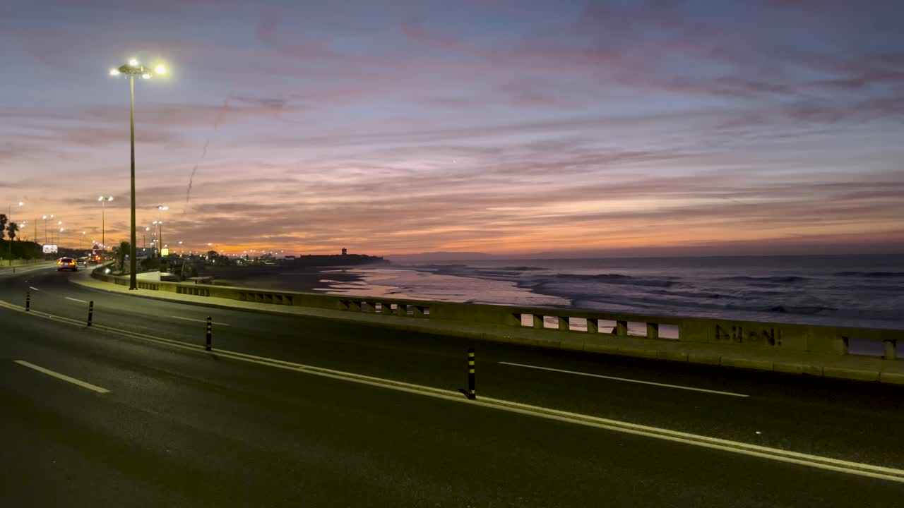puesta de sol en una playa portuguesa con vistas al mar, y una calle con coches cerca