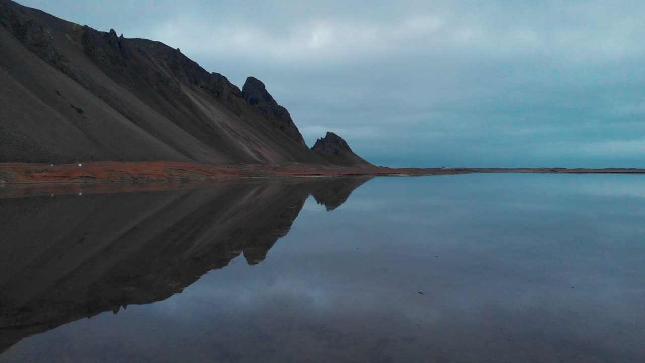vestrahorn montaña espejo reflejo en la tranquila costa oceánica de stokksnes, vista aérea