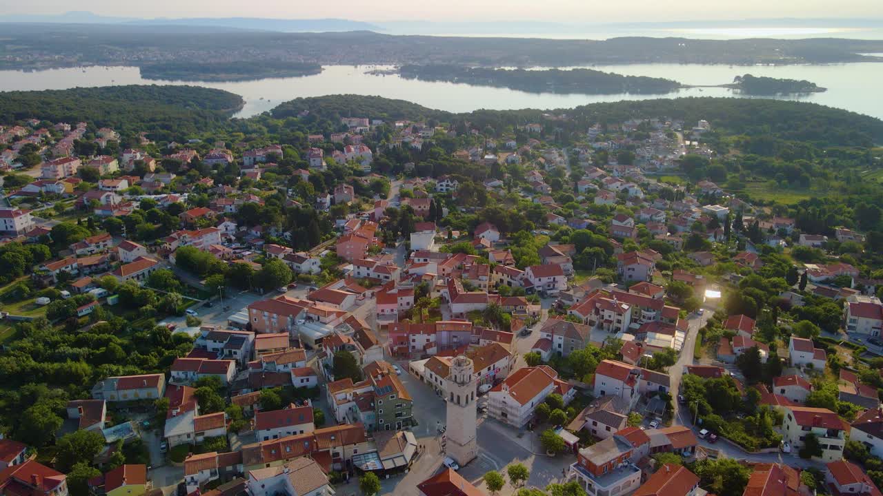 An impressive drone image reveals a city swathed in copious verdure and immersed in delightful sunlight, complete with a captivating sea view