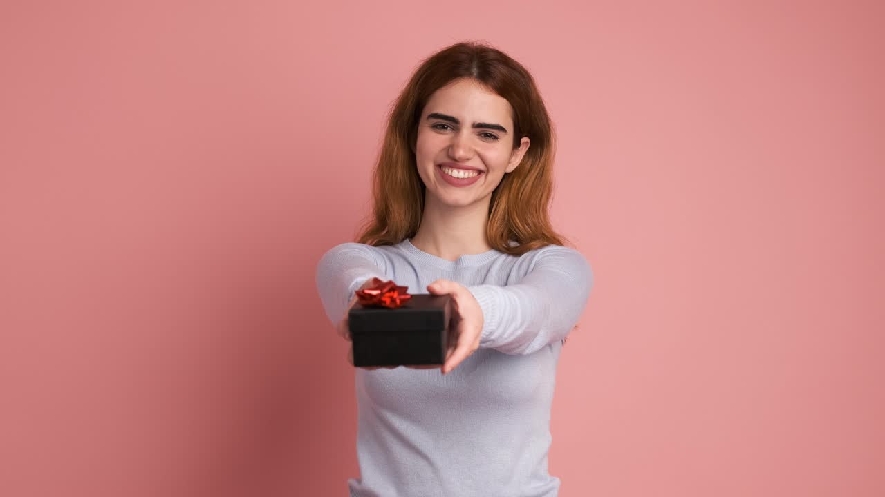 Happy woman giving a present and smiling to camera