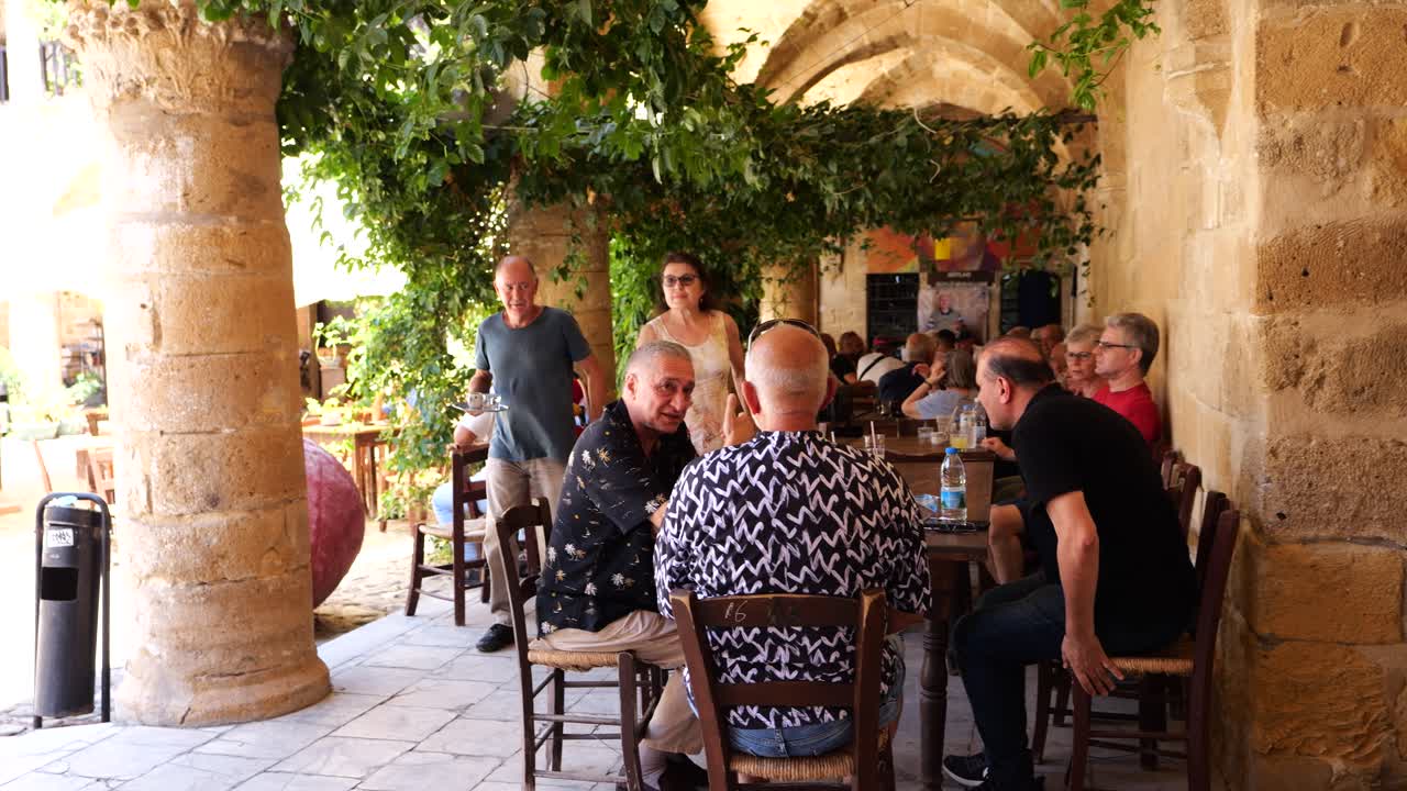 People Outdoor Dining In Courtyard, Nicosia. Slow Motion Pan Left