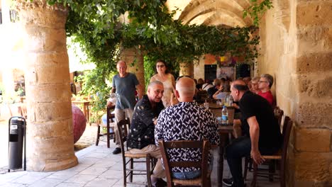people outdoor dining in courtyard, nicosia. slow motion pan left