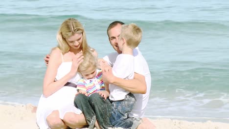 family sitting on the beach