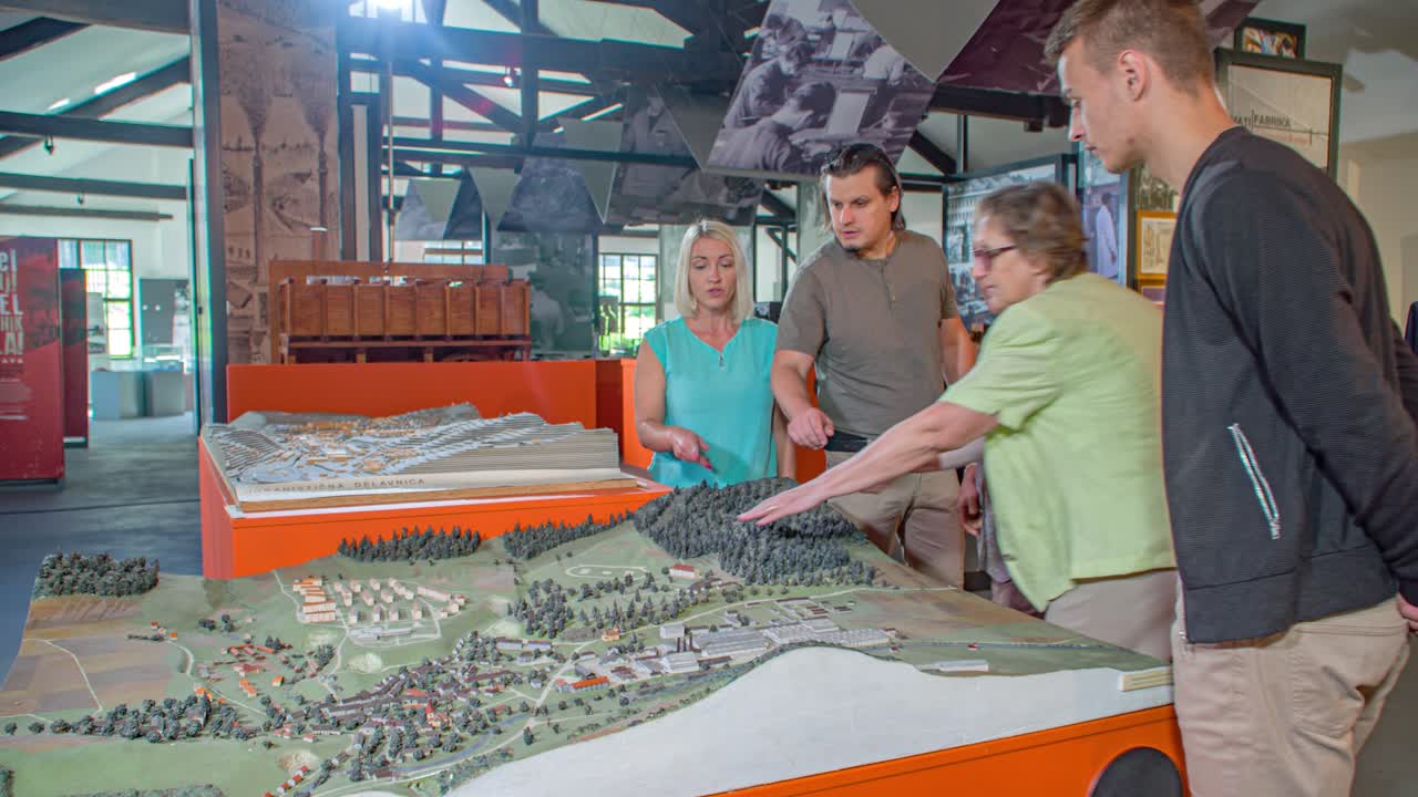 Tourists visit iron making museum, steel industry. Model scale of area. Arc shot