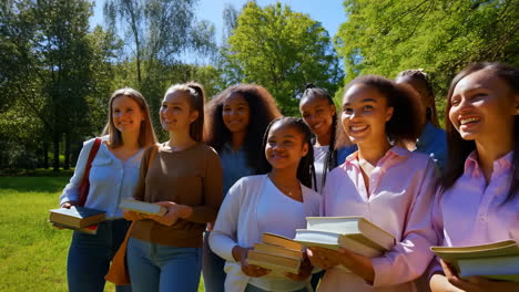 diverse group of female students with books walking on campus