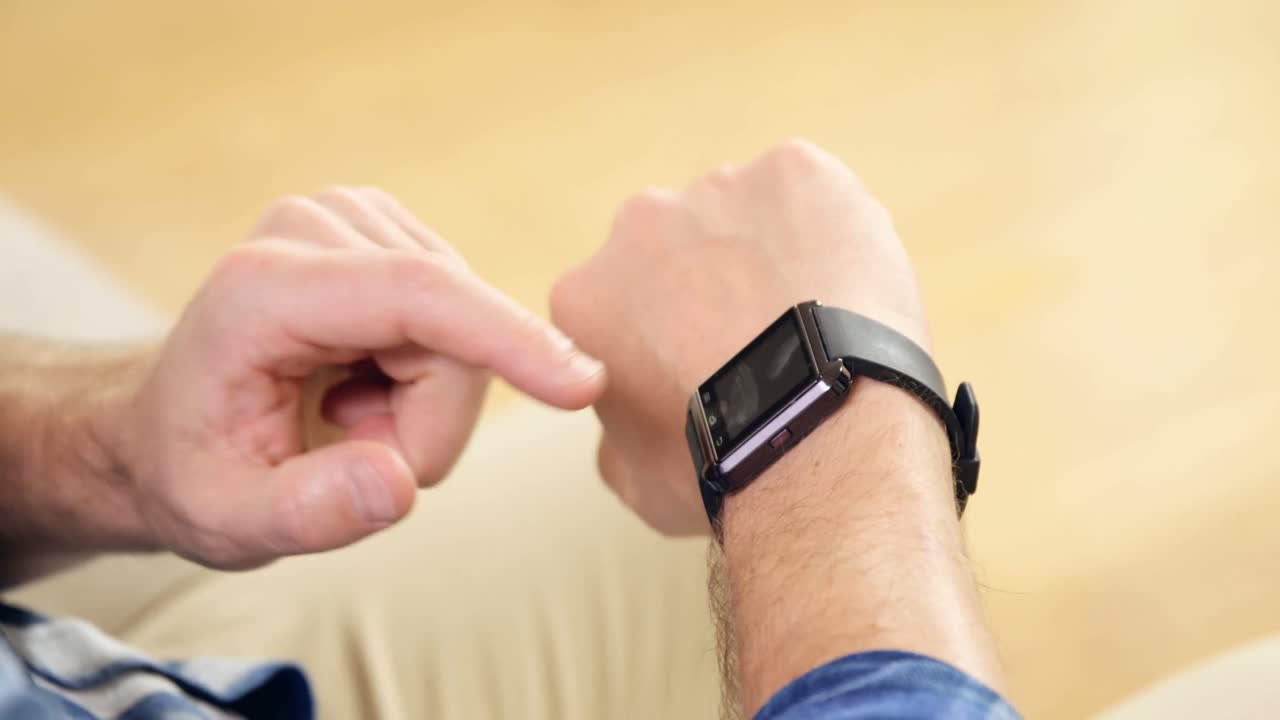 Smiling man using smartwatch