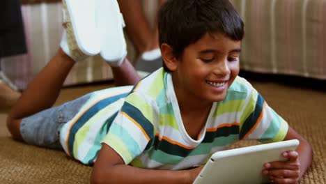 Boy-using-digital-tablet-in-living-room