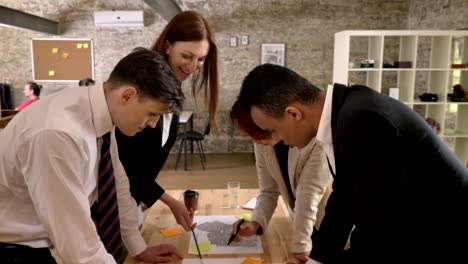 business team of mixed ethnicity are holding meeting in modern office building, speaking and discussing project