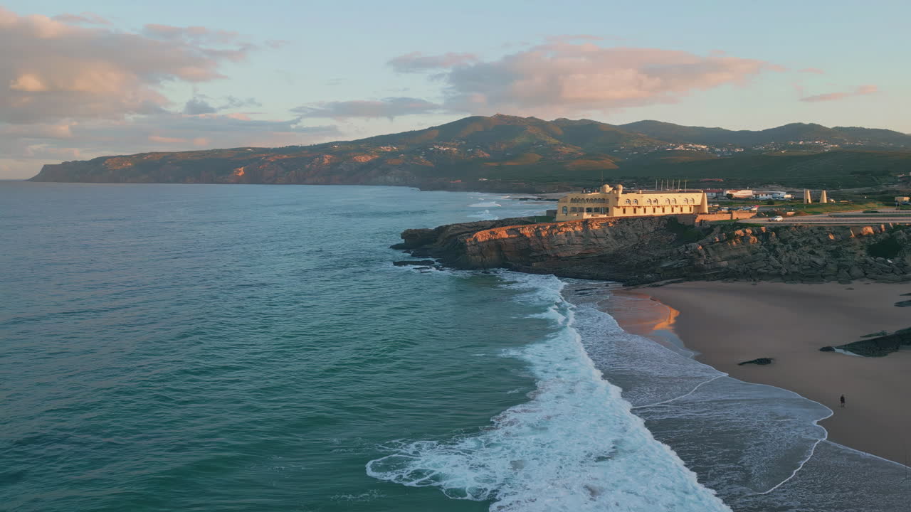 Aerial serene coastal evening with town landscape. Golden sunset light on cliffs