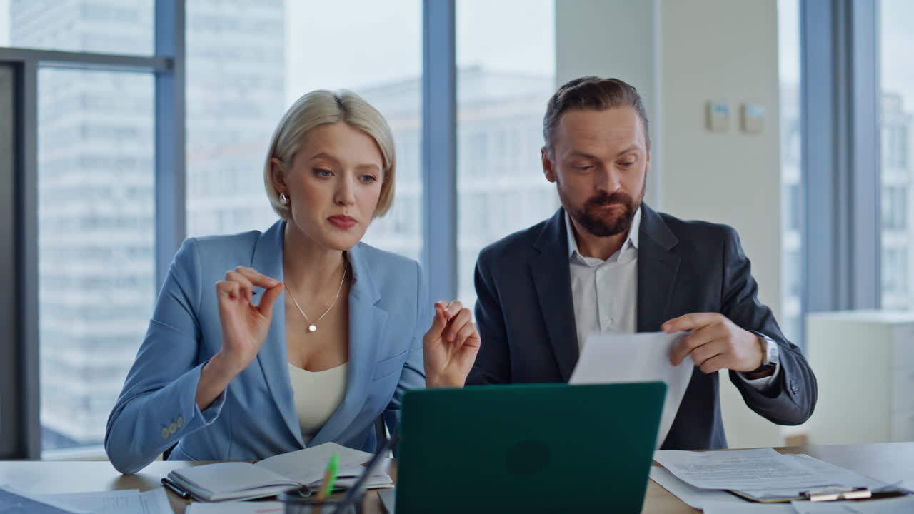 Emotional coworkers arguing virtual meeting looking laptop in office closeup