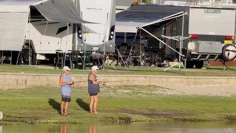 people fishing near trailers and waterfront