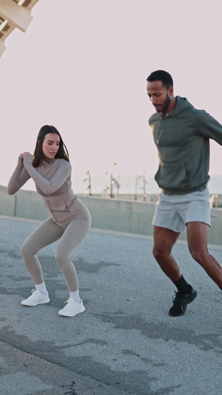Personal Trainer Coaching Woman During Outdoor Squat Jump Exercise