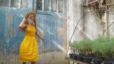 woman in yellow dress and straw hat in a garden shed