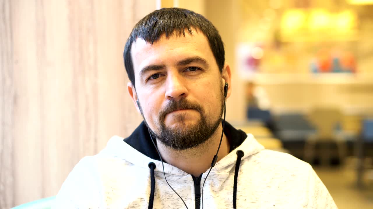 un joven sonriendo a la cámara en el café.