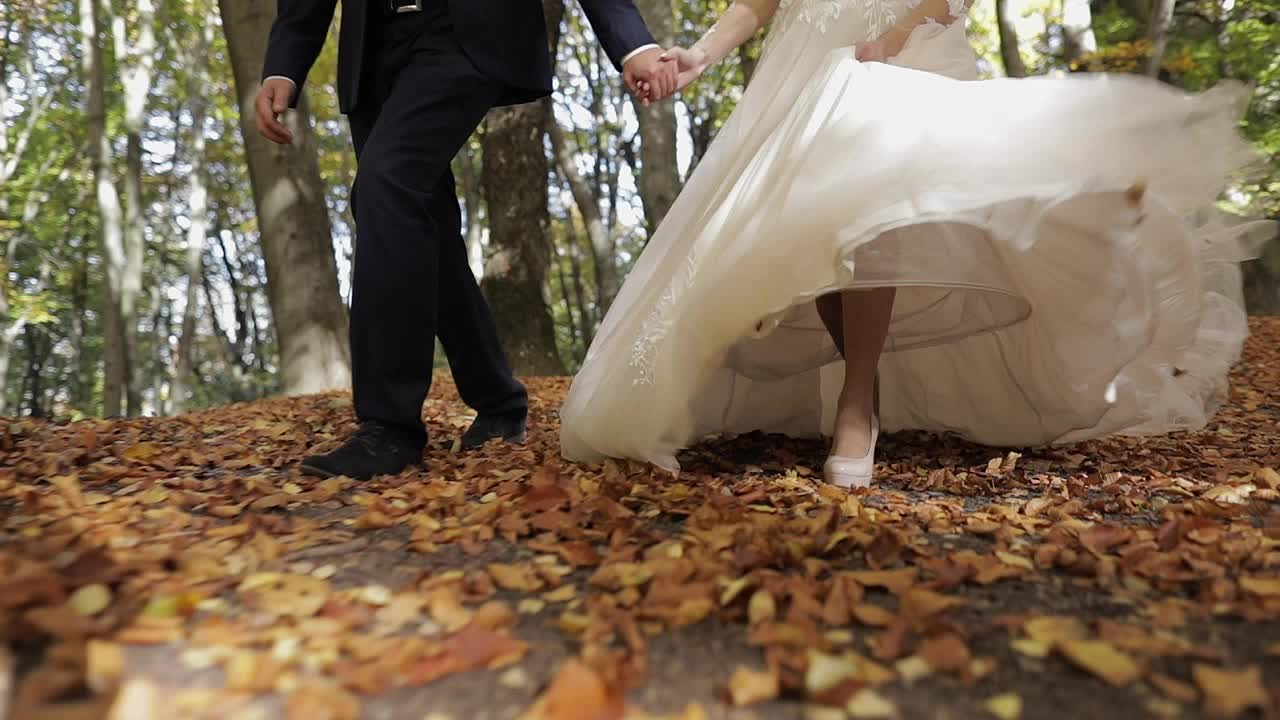 Legs of groom with bride in the forest park. Wedding couple. Happy family