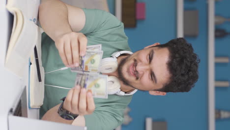 video vertical de un estudiante feliz ganando dinero.
