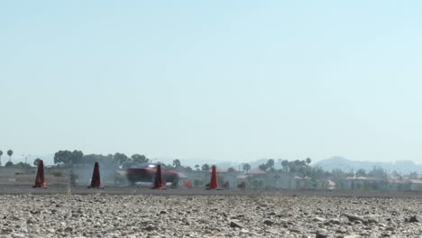 Tiro-Bajo-De-Un-Coche-Rojo-Que-Fuma-Sus-Neumáticos-A-Través-De-Un-Curso-De-Deriva-En-El-Aeropuerto-De-Camarillo-En-Camarillo-California