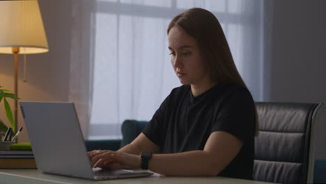 Müde-Frau-Arbeitet-Abends-Mit-Notebook-Im-Home-Office,-Tippt-Text-Auf-Der-Tastatur-Und-Atmet-Schwer,-Erschöpft-Und-überarbeitet,-Weibliche-Arbeiterin