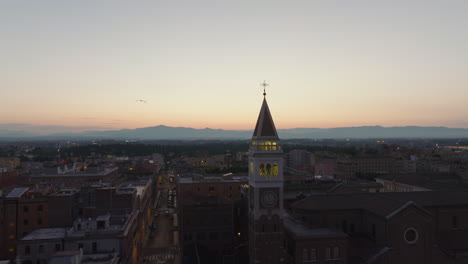 Forwards-fly-above-buildings-in-historic-city-centre.-Silhouette-of-old-tower-against-colour-twilight-sky.-Rome,-Italy