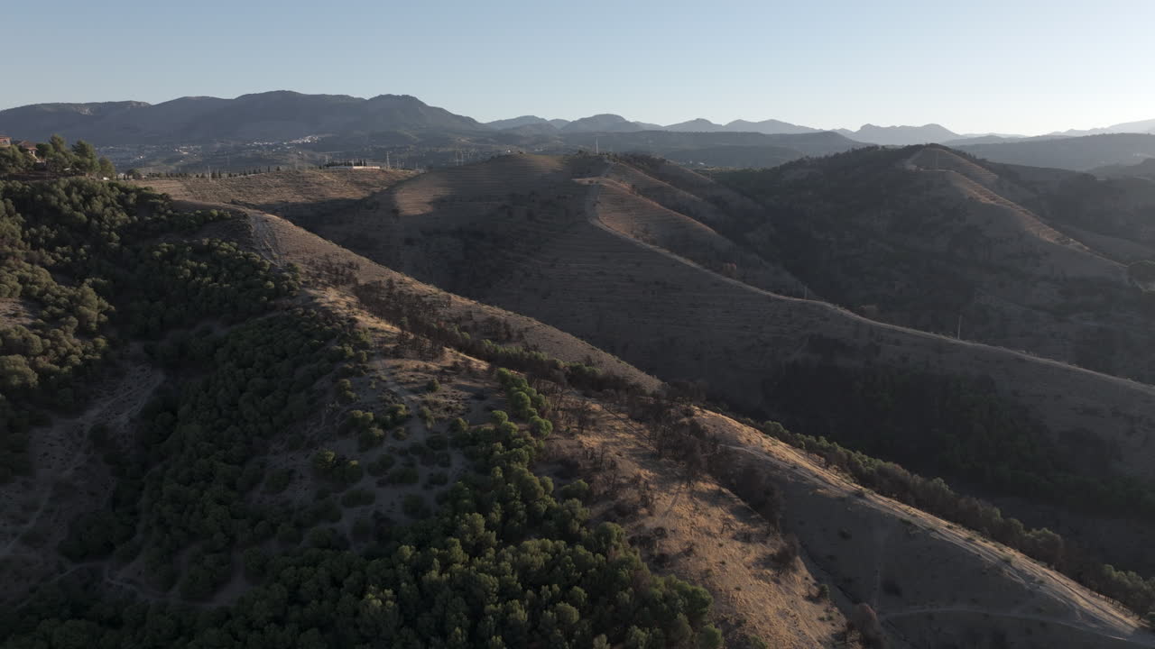 Aerial drone wide view of Granada rolling hills and Sierra Nevada mountains in Andalusia, Spain, Europe, at sunrise, early morning in summer