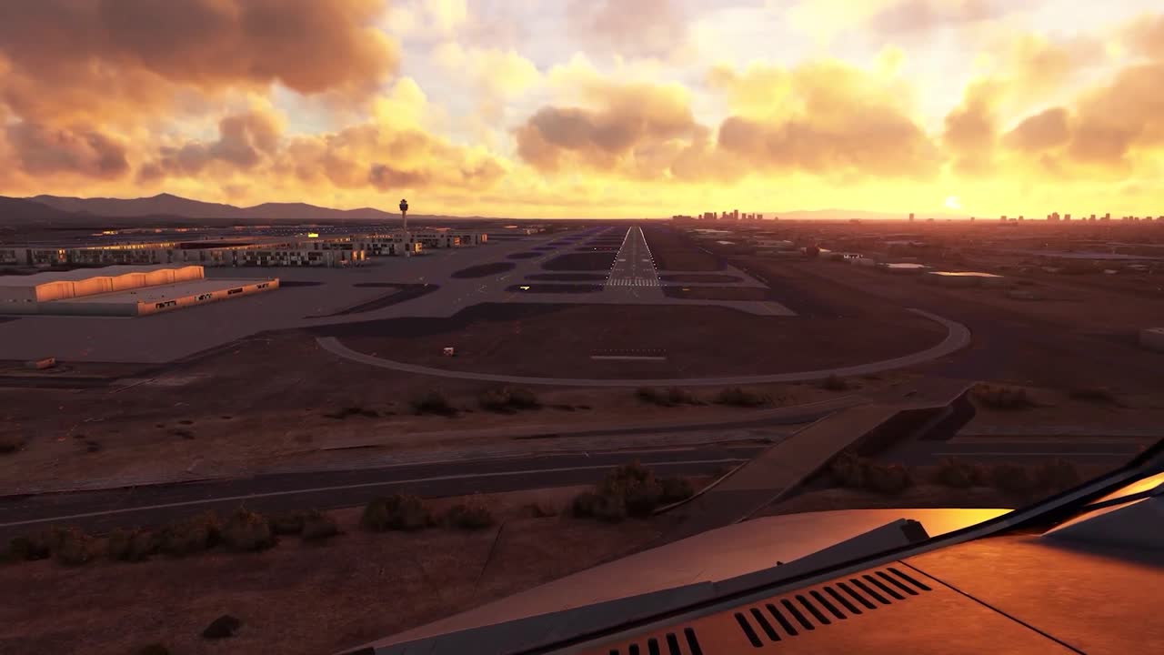 FPV or firs person footage from inside a small airplane flying over a small city with cars and houses and approaching a small landing strip during a vibrant orange sunset or sunrise.