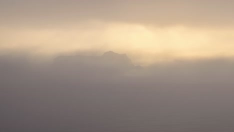 island amidst thick clouds in morning