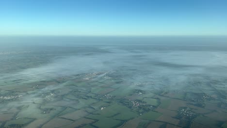 nebelige landschaft, aufgenommen von einem jet während des anflugs auf den flughafen von nantes, frankreich, an einem sonnigen herbstmorgen